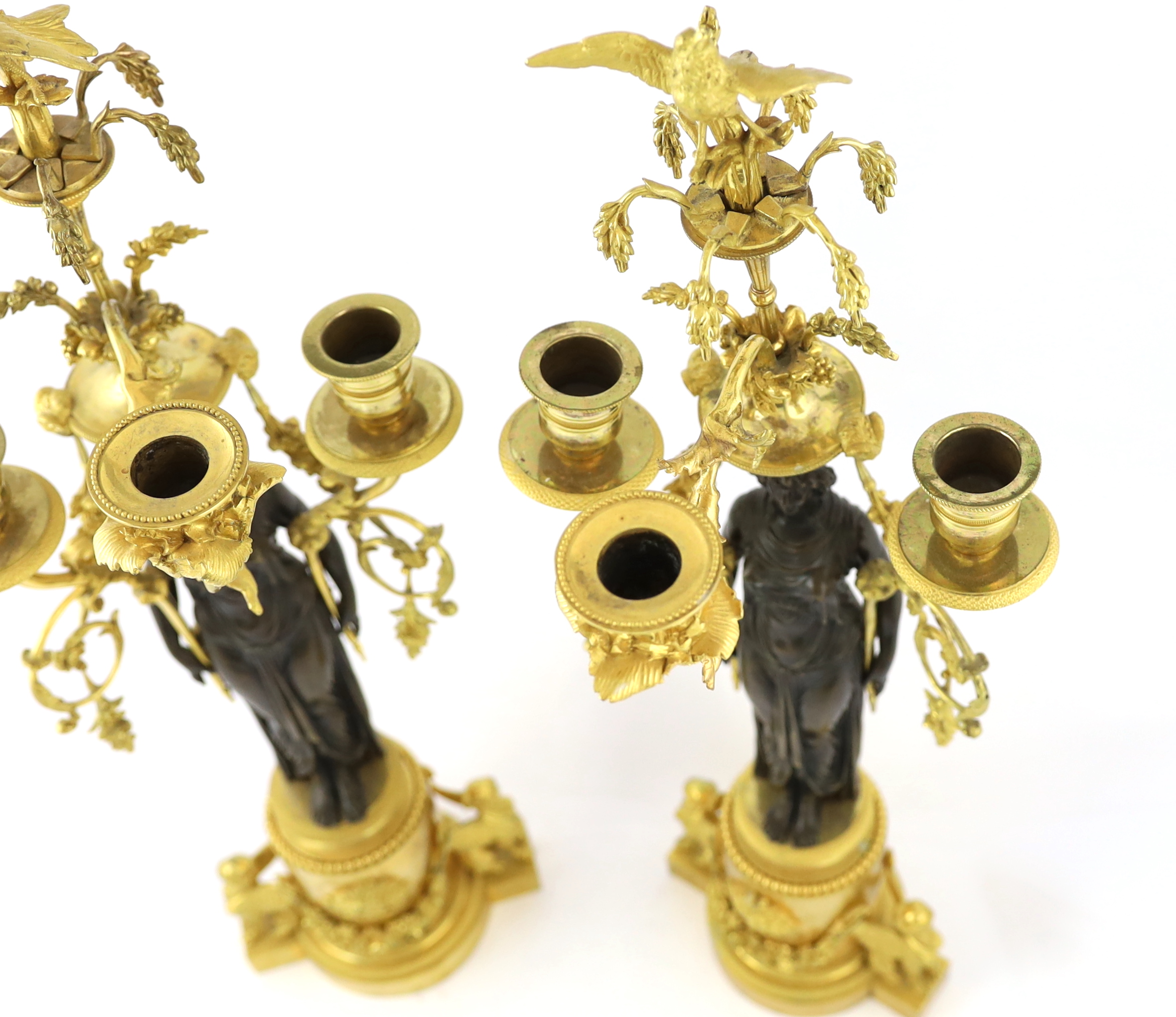 A pair of late 19th century French Empire style bronze and ormolu three light candelabra, 20cm wide, 63cm high, Please note this lot attracts an additional import tax of 5% on the hammer price